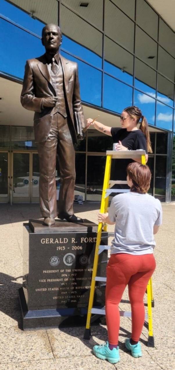 Meghan and fellow intern Valen Vennard cleaning the Gerald R. Ford statue at the Ford Presidential Museum.